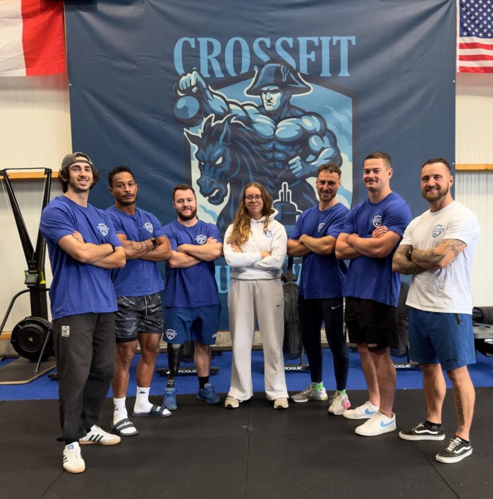 staff de l'entreprise posant devant la bannière de la salle.